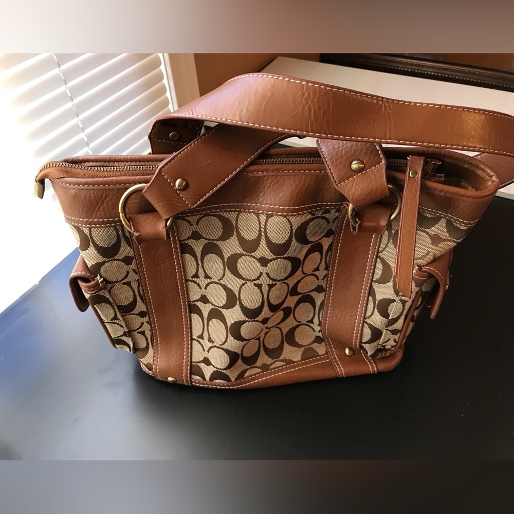 Beige and brown handbag 13”x 9.5”. Two outside pockets, 3 inside pockets